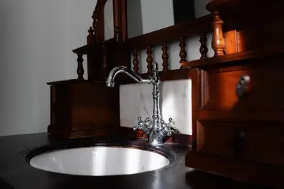 a sink in a bathroom with a wooden cabinet at Hotel Jardin in Belgrade