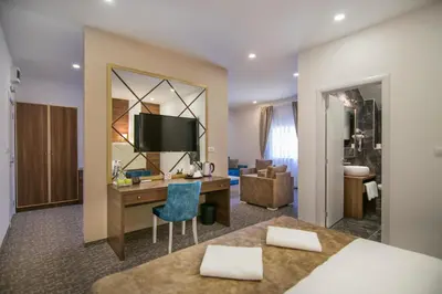 a hotel room with a desk and a bedroom at Luxury Rooms Skadarlija in Belgrade