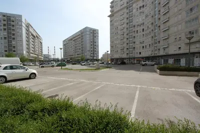 an empty parking lot in a city with tall buildings at New Belgrade Apartments, parking 5 eur per day in Belgrade