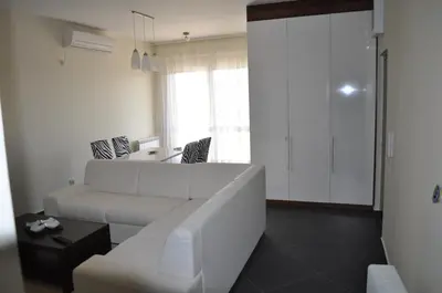 a living room with a white couch and a table at Apartments Soleado in Pančevo