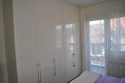 a white room with a bed and a window at Apartments Soleado in Pančevo