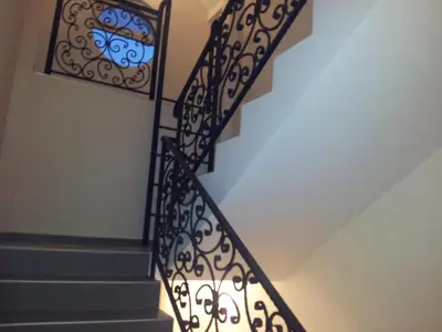 a staircase with a wrought iron railing with a stained glass window at Apartments Soleado in Pančevo