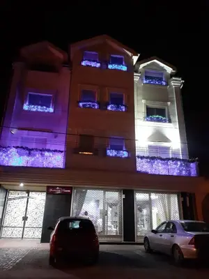 a building with blue lights on the windows at night at Apartments Soleado in Pančevo