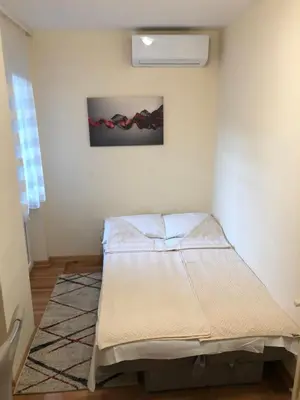 a bed in a room with a painting on the wall at Burgundy Apartment in Belgrade