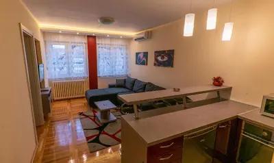a living room with a blue couch and a table at Burgundy Apartment in Belgrade
