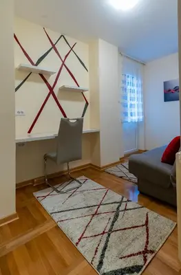 a living room with a couch and a chair at Burgundy Apartment in Belgrade