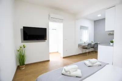 a white apartment with two towels on a bed at Airport Stay Apartments in Surčin