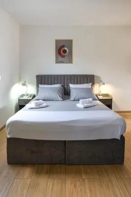 a large bed in a bedroom with two night stands at Airport Stay Apartments in Surčin