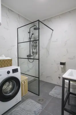 a bathroom with a washing machine and a shower at Airport Stay Apartments in Surčin