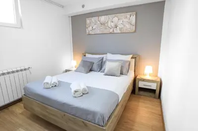a bedroom with a bed with towels on it at Airport Stay Apartments in Surčin