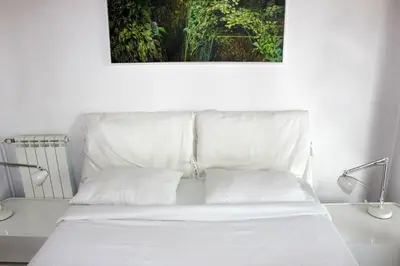 a white bed with two pillows in a room at STATUS Superior Apartments in Belgrade