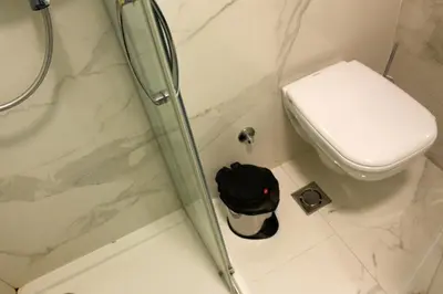 a bathroom with a toilet and a glass shower door at STATUS Superior Apartments in Belgrade