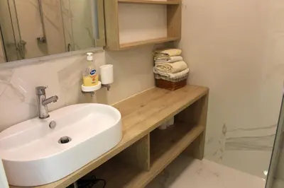 a bathroom with a sink and a mirror and towels at STATUS Superior Apartments in Belgrade
