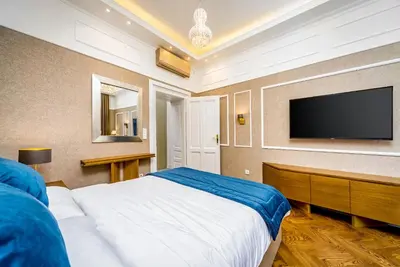 a bedroom with a large bed and a flat screen tv at Royal Knez in Belgrade
