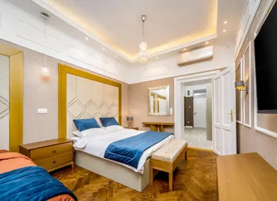 a bedroom with a large bed and a table at Royal Knez in Belgrade