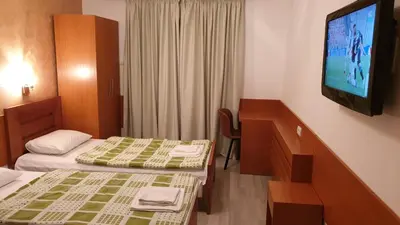 a hotel room with two beds and a flat screen tv at Guest House Boska in Pančevo