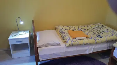 a small bedroom with a bed and a night stand at Guest House Boska in Pančevo