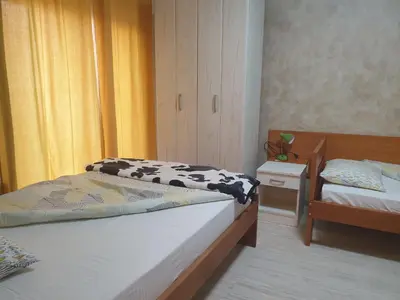 a bedroom with two beds and a nightstand and a bed sidx sidx at Guest House Boska in Pančevo