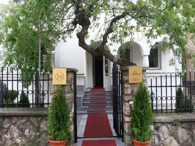 a gate to a white house with a red carpet at Villa Mystique in Belgrade