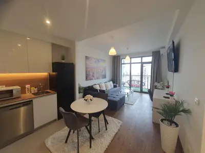 a kitchen and living room with a table and a couch at Belgrade Waterfront - Beograd na vodi in Belgrade