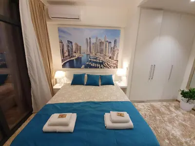 a bedroom with a blue bed with towels on it at Belgrade Waterfront - Beograd na vodi in Belgrade