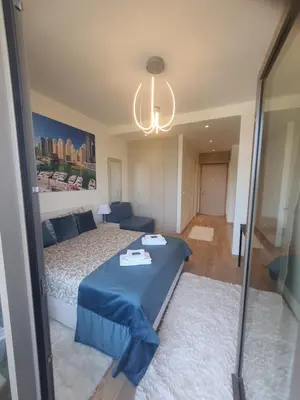 a bedroom with a blue bed and a chandelier at Belgrade Waterfront - Beograd na vodi in Belgrade