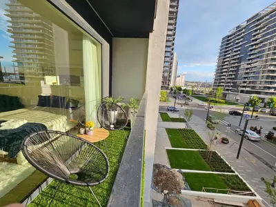a balcony with two chairs and a garden on a building at Belgrade Waterfront - Beograd na vodi in Belgrade