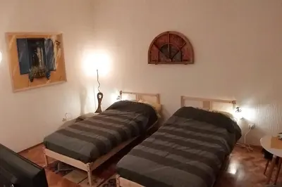 two beds in a room with a table and a window at BGMignonne, so cozy, so relaxing, so near center in Belgrade
