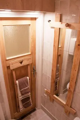 a bathroom with a shower with a wooden door at BGMignonne, so cozy, so relaxing, so near center in Belgrade