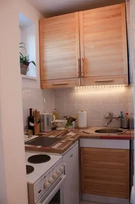 a kitchen with wooden cabinets and a white stove top oven at BGMignonne, so cozy, so relaxing, so near center in Belgrade