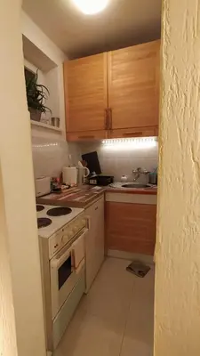 a kitchen with wooden cabinets and a stove top oven at BGMignonne, so cozy, so relaxing, so near center in Belgrade