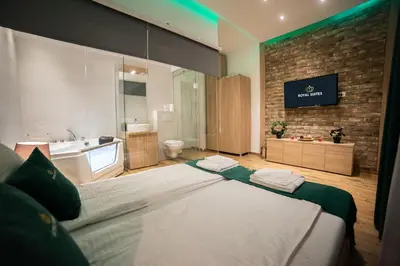 a bedroom with a large bed and a bathroom at Royal Suites in Belgrade