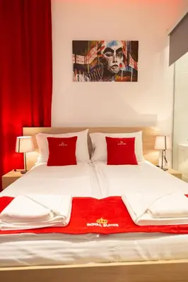 a bedroom with a large bed with red pillows at Royal Suites in Belgrade