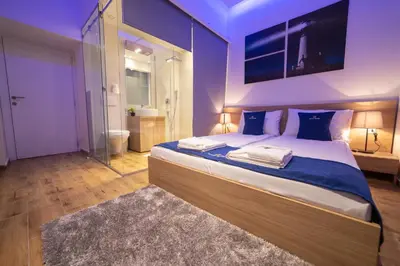 a bedroom with a large bed and a bathroom at Royal Suites in Belgrade