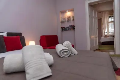 a living room with a bed with towels on it at Sweet House Trg in Belgrade