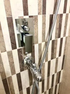 a shower with a hose attached to a wall at Apartment on a river avenue in Pančevo