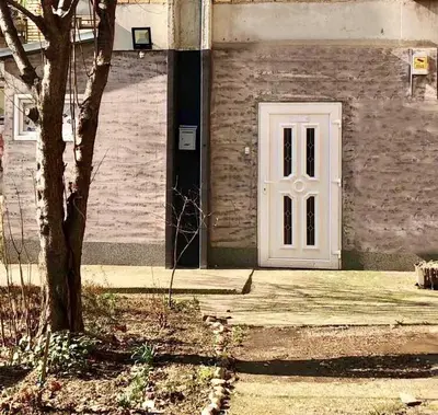 a white door on a brick building with a tree at Apartment on a river avenue in Pančevo