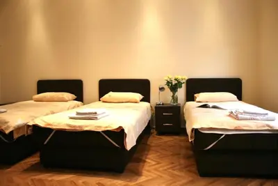 a room with two beds and a vase of flowers at Belgrade Stay Apartments in Belgrade