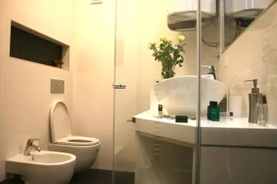 a white bathroom with a toilet and a sink at Belgrade Stay Apartments in Belgrade