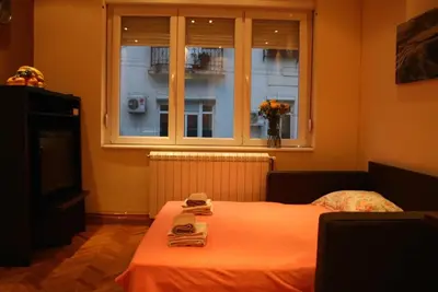 a bedroom with a bed with a window and a table at Belgrade Stay Apartments in Belgrade