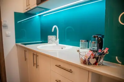 a bathroom with a sink and a counter with a basket of tooth brushes at Drop In Apartments in Belgrade
