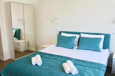 a bedroom with a large bed with blue and white pillows at Drop In Apartments in Belgrade