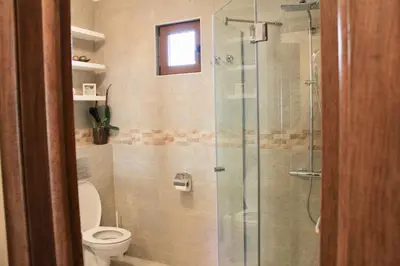 a bathroom with a toilet and a glass shower at Drop In Apartments in Belgrade