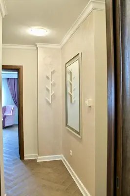 a hallway with a mirror and a room with a bed at Drop In Apartments in Belgrade