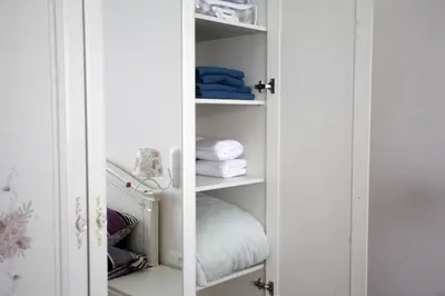 a closet with white shelves and towels in it at City Center Belgrade Queen Apartment Skadarlija in Belgrade