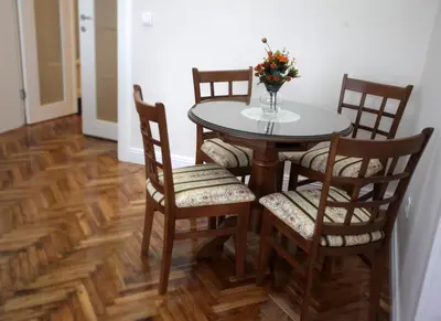 a dining room table and chairs with a vase of flowers at City Center Belgrade Queen Apartment Skadarlija in Belgrade