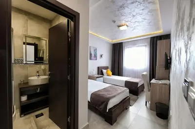 a hotel room with two beds and a sink at Garnet Hotel & Event Centar in Ruma