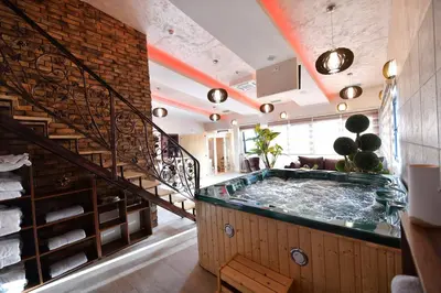 a hot tub in a room with a staircase at Garnet Hotel & Event Centar in Ruma