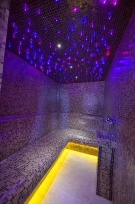 a room with a tub with purple lights on it at Garnet Hotel & Event Centar in Ruma