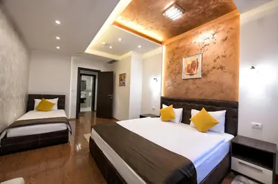 a bedroom with two beds with yellow pillows at Garnet Hotel & Event Centar in Ruma